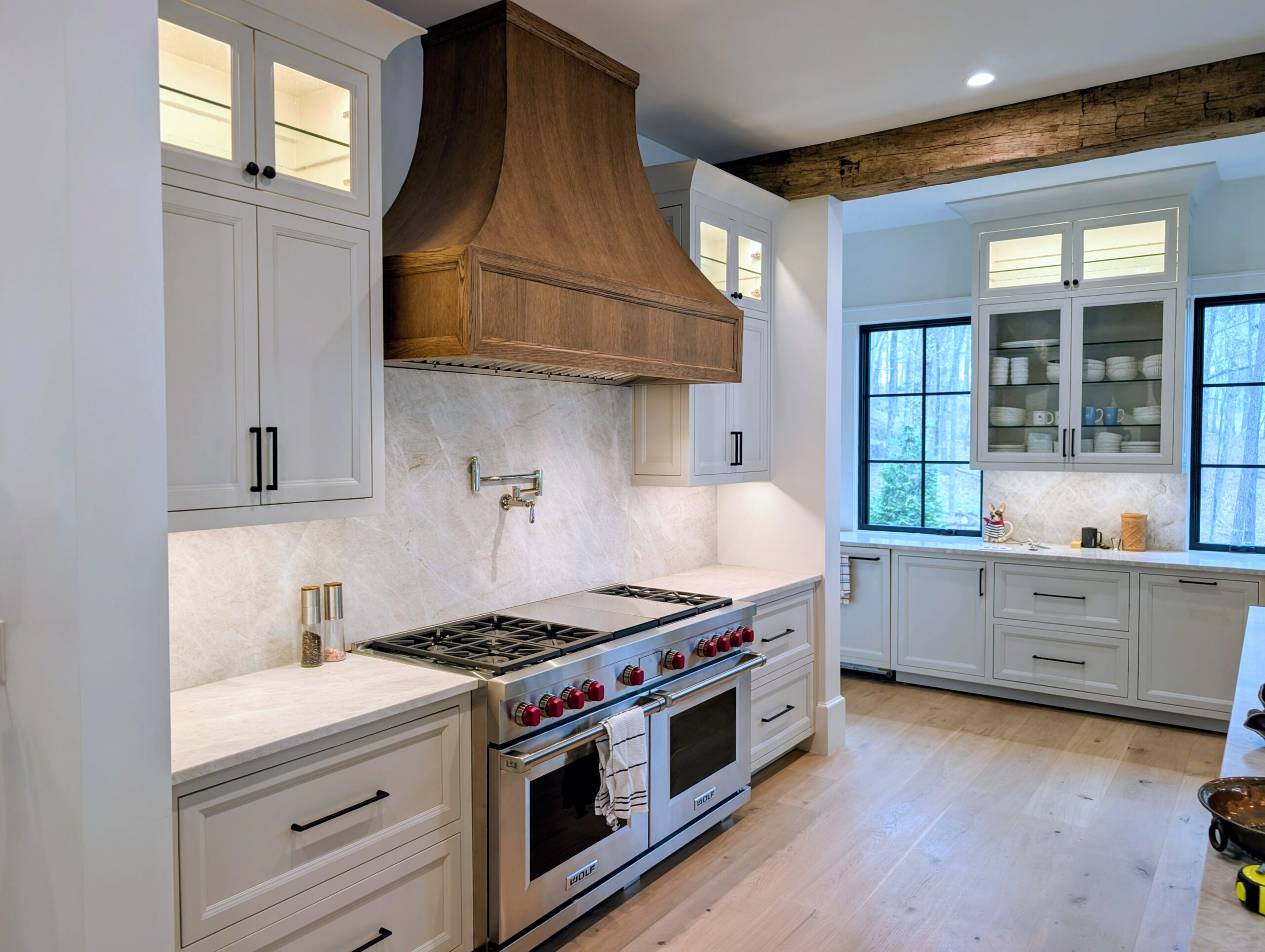 Custom kitchen with copper range hood and glass-front upper cabinets by Carlyle Cabinets